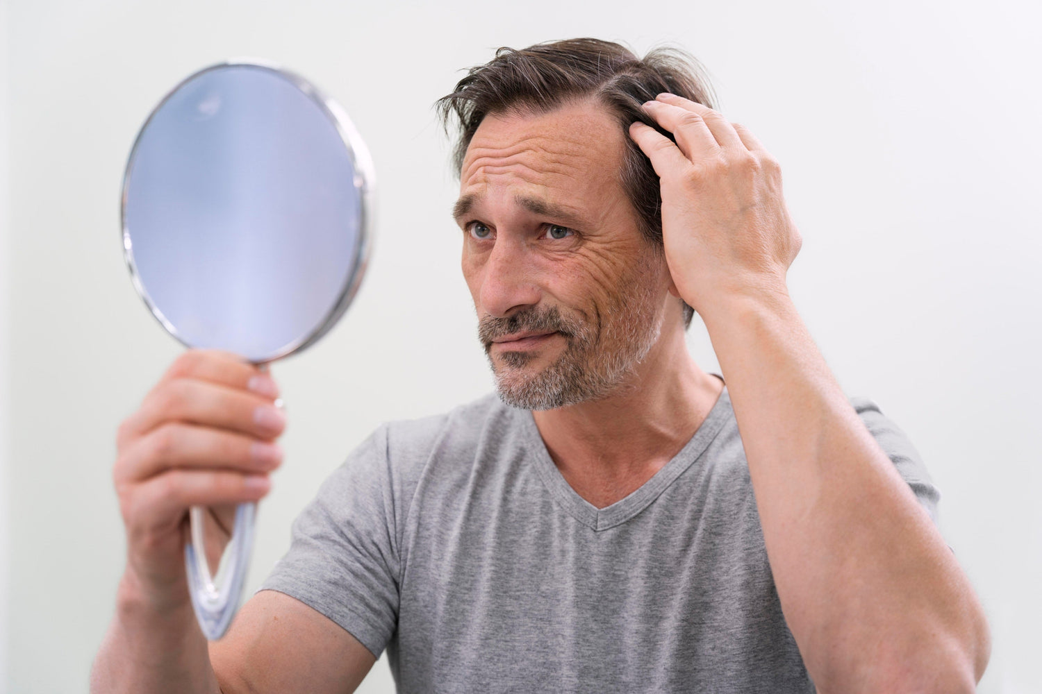 Homme regardant ses cheveux dans un miroir 